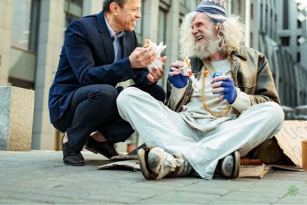un passante che dona cibo ad un senza tetto